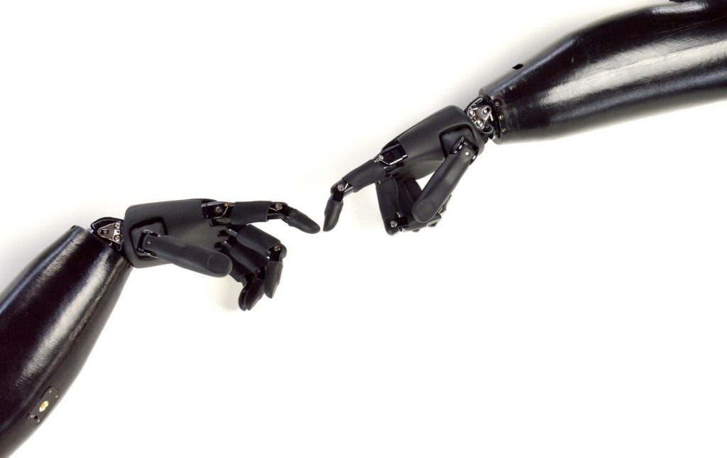 zwei Roboterhände berühren sich an den Zeigefingern